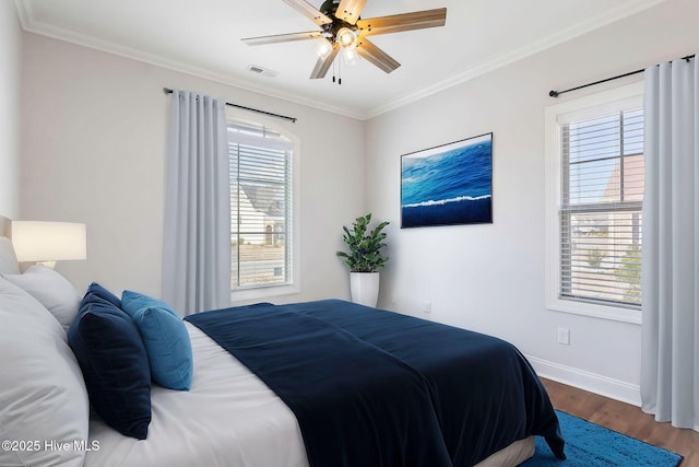 bedroom with hardwood / wood-style flooring, ornamental molding, and ceiling fan