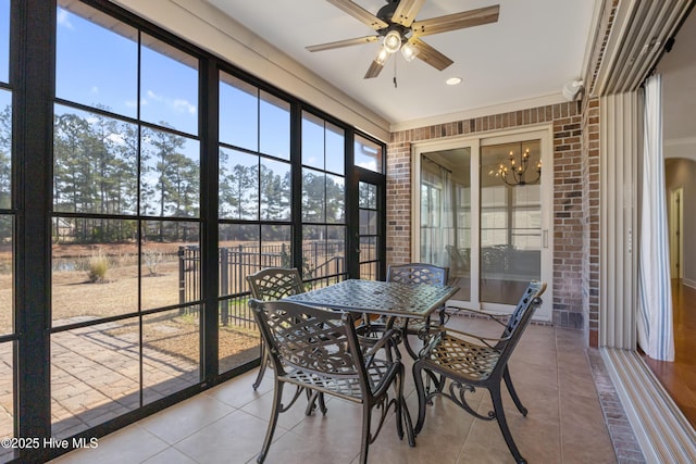 sunroom with ceiling fan with notable chandelier