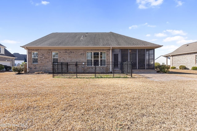 back of house with a lawn and a sunroom