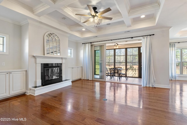 unfurnished living room with hardwood / wood-style floors, ornamental molding, coffered ceiling, ceiling fan, and beam ceiling