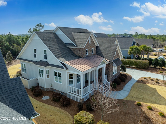 exterior space featuring metal roof, a porch, roof with shingles, crawl space, and a standing seam roof