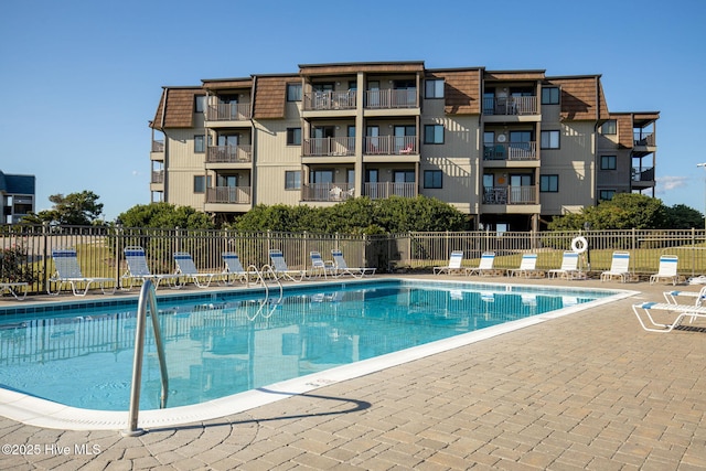 view of swimming pool featuring fence and a patio