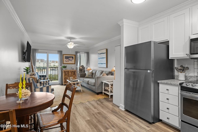 kitchen with appliances with stainless steel finishes, white cabinetry, light wood-style flooring, and crown molding