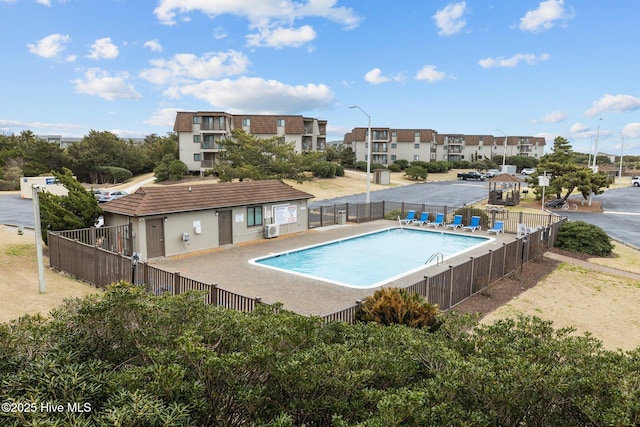 pool featuring cooling unit, fence, and a patio