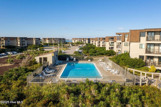 community pool featuring a patio and fence