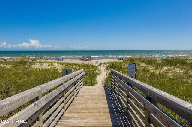 surrounding community with a water view and a beach view