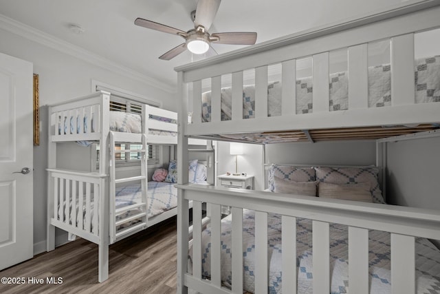 bedroom with a ceiling fan, crown molding, and wood finished floors