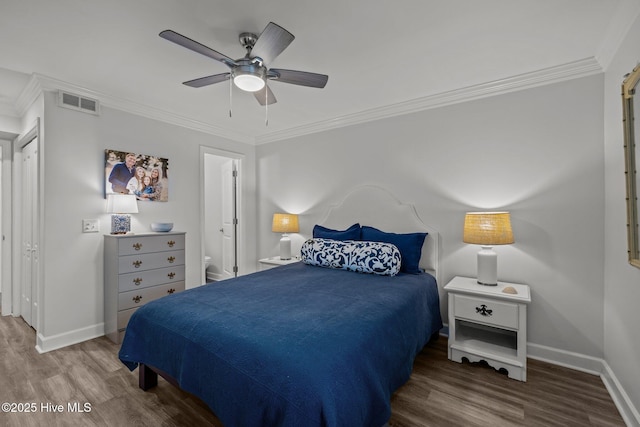 bedroom featuring ornamental molding, wood finished floors, and visible vents