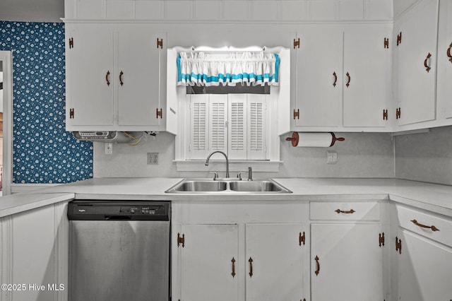 kitchen featuring dishwasher, sink, and white cabinets