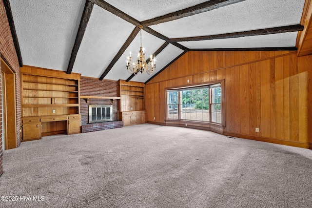 unfurnished living room featuring vaulted ceiling with beams, carpet, a textured ceiling, a brick fireplace, and wood walls