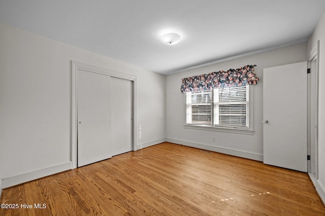 unfurnished bedroom featuring a closet and light hardwood / wood-style flooring