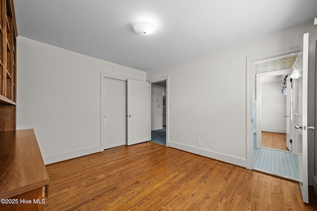 unfurnished bedroom with hardwood / wood-style floors and a closet