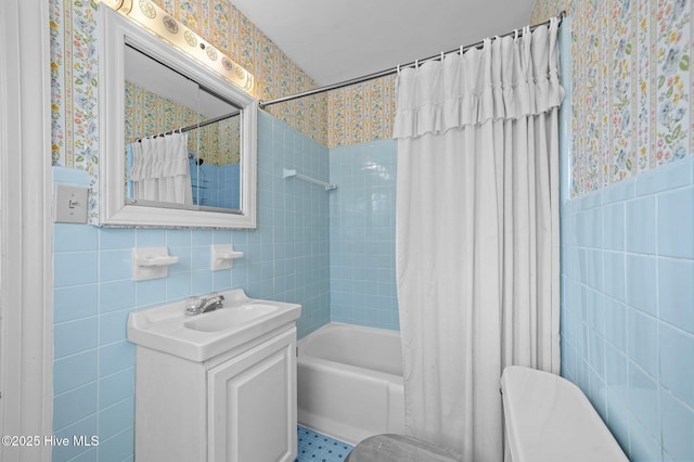 bathroom with tile walls, vanity, and shower / bath combination with curtain