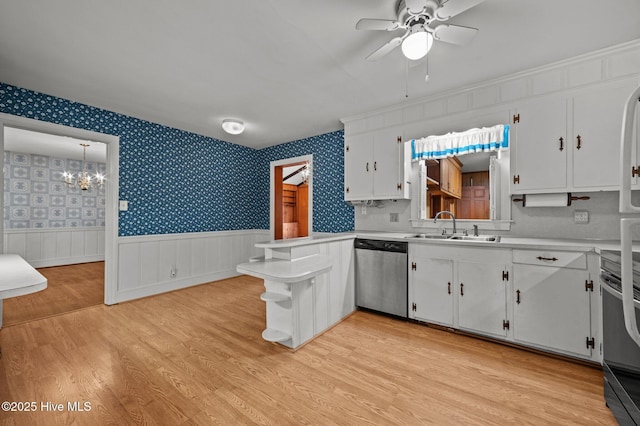 kitchen featuring sink, light hardwood / wood-style flooring, white cabinetry, stainless steel appliances, and kitchen peninsula