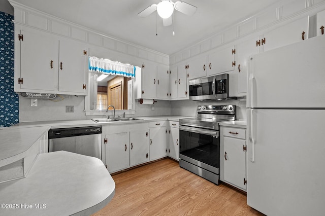 kitchen featuring sink, appliances with stainless steel finishes, ceiling fan, light hardwood / wood-style floors, and white cabinets