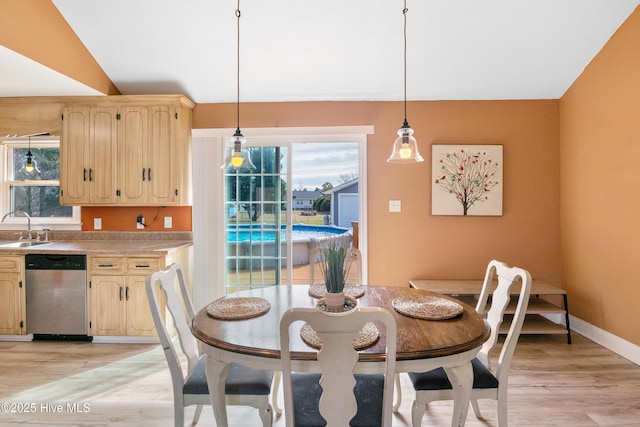 dining space featuring vaulted ceiling, light hardwood / wood-style floors, and sink