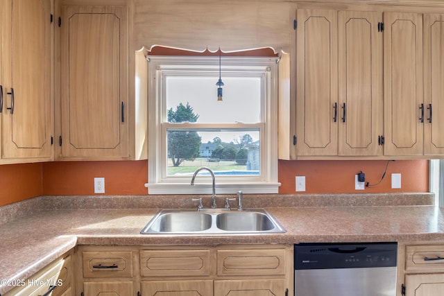 kitchen with stainless steel dishwasher, light brown cabinetry, sink, and hanging light fixtures