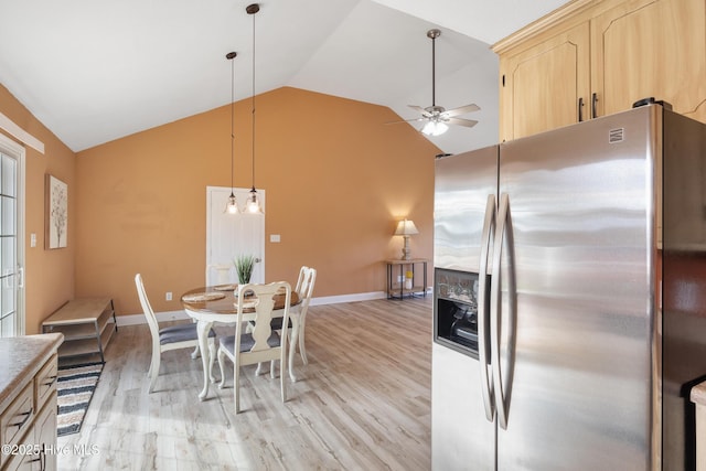 kitchen with stainless steel refrigerator with ice dispenser, light brown cabinetry, vaulted ceiling, hanging light fixtures, and ceiling fan