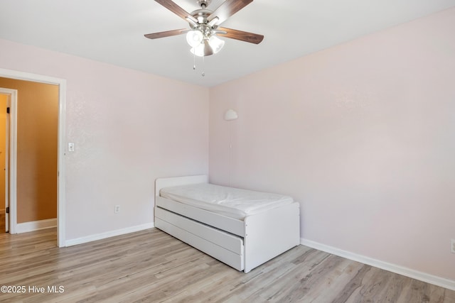 unfurnished bedroom with ceiling fan, washer / dryer, and light wood-type flooring