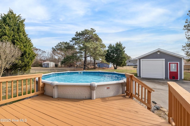 view of pool featuring a wooden deck, a garage, and an outdoor structure