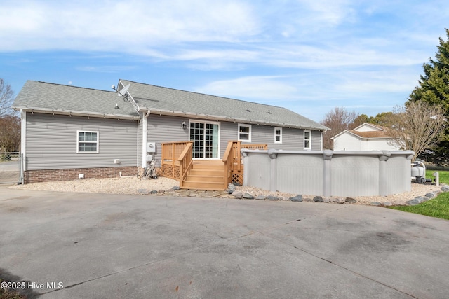 rear view of house featuring a swimming pool side deck