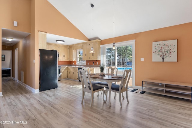 dining area with high vaulted ceiling, sink, and light hardwood / wood-style floors