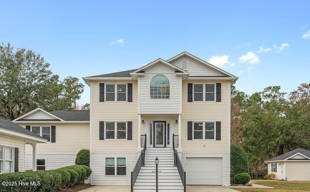 view of front of property featuring a garage, driveway, and stairway