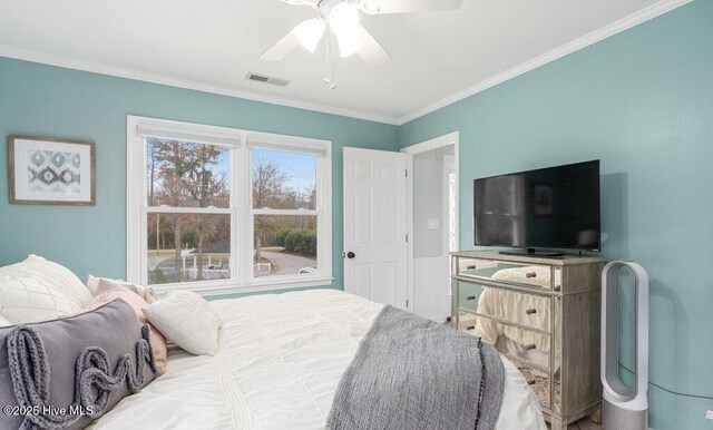 empty room featuring visible vents, dark wood-type flooring, ornamental molding, wainscoting, and ceiling fan