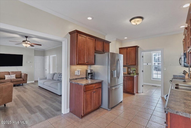 kitchen with crown molding, light tile patterned floors, appliances with stainless steel finishes, ceiling fan, and backsplash