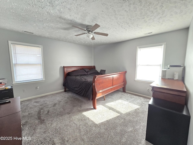 carpeted bedroom with ceiling fan and a textured ceiling