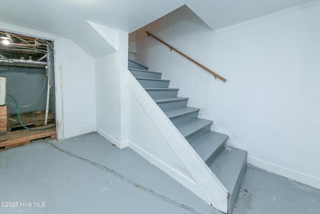 stairway featuring concrete flooring and baseboards