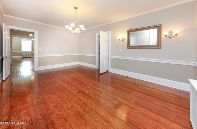 empty room featuring crown molding, radiator, wood finished floors, a chandelier, and baseboards