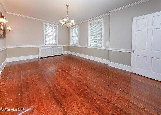 spare room featuring baseboards, crown molding, radiator heating unit, and wood finished floors