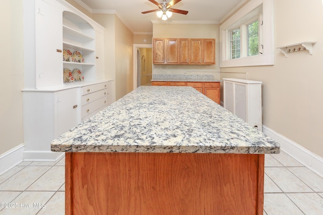 kitchen featuring light tile patterned floors, baseboards, open shelves, and crown molding