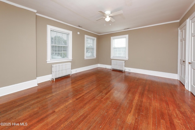 spare room featuring radiator heating unit, wood finished floors, and crown molding