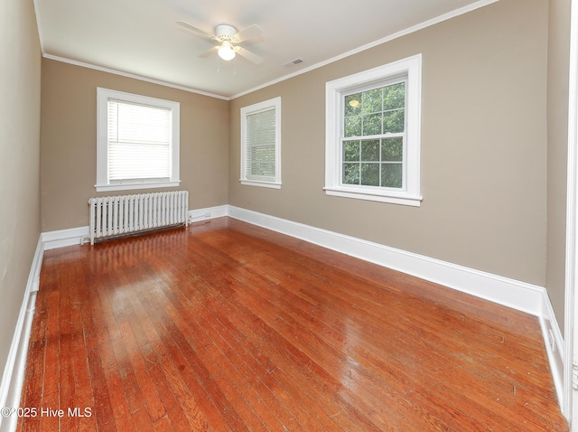 empty room with baseboards, ornamental molding, visible vents, and radiator