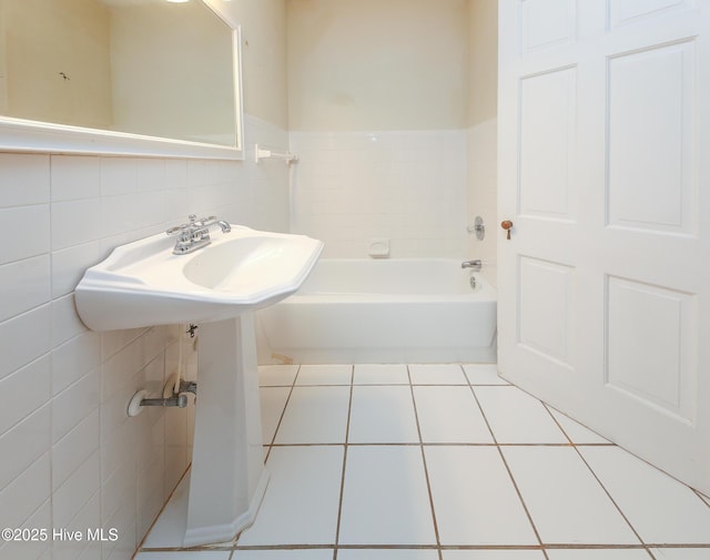 full bathroom with tile walls, a bath, and tile patterned floors