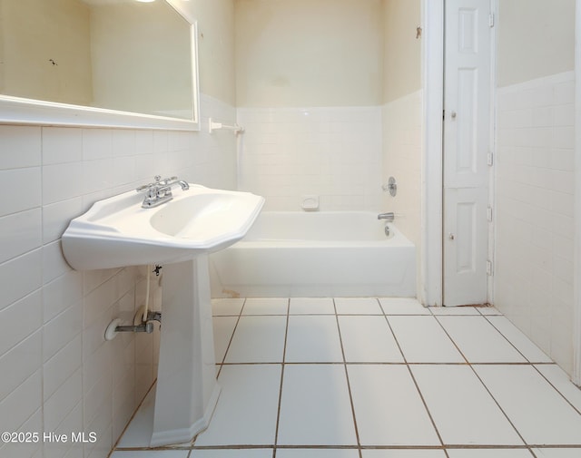 full bathroom featuring tile patterned flooring, tile walls, and a bathing tub