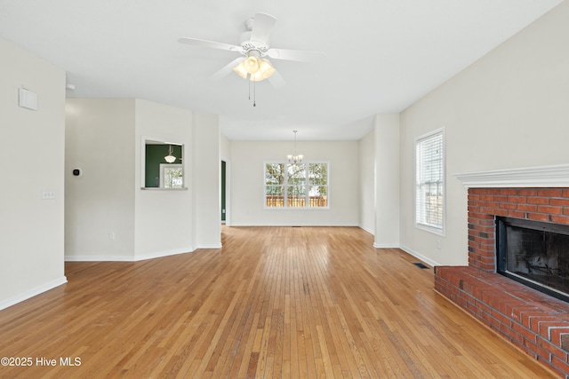 1652 Chadwick Shores Dr, Sneads Ferry, NC 28460 - unfurnished living room with light wood-style floors, a chandelier, a brick fireplace, and baseboards