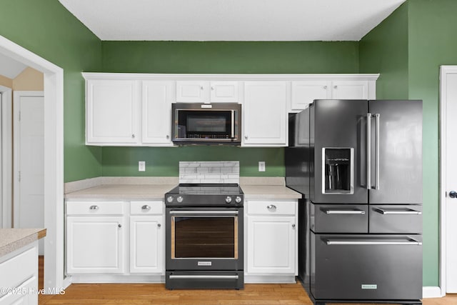1652 Chadwick Shores Dr, Sneads Ferry, NC 28460 - kitchen featuring appliances with stainless steel finishes, light countertops, white cabinetry, and light wood finished floors