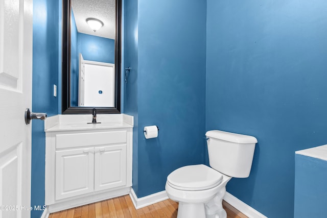 1652 Chadwick Shores Dr, Sneads Ferry, NC 28460 - bathroom with toilet, baseboards, wood finished floors, vanity, and a textured ceiling