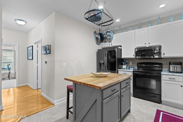 kitchen with gray cabinets, wooden counters, white cabinetry, stainless steel appliances, and a center island