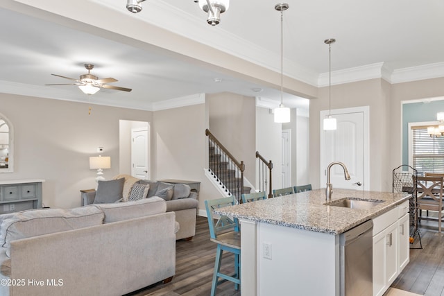 kitchen featuring dishwasher, sink, white cabinets, a kitchen island with sink, and light stone counters