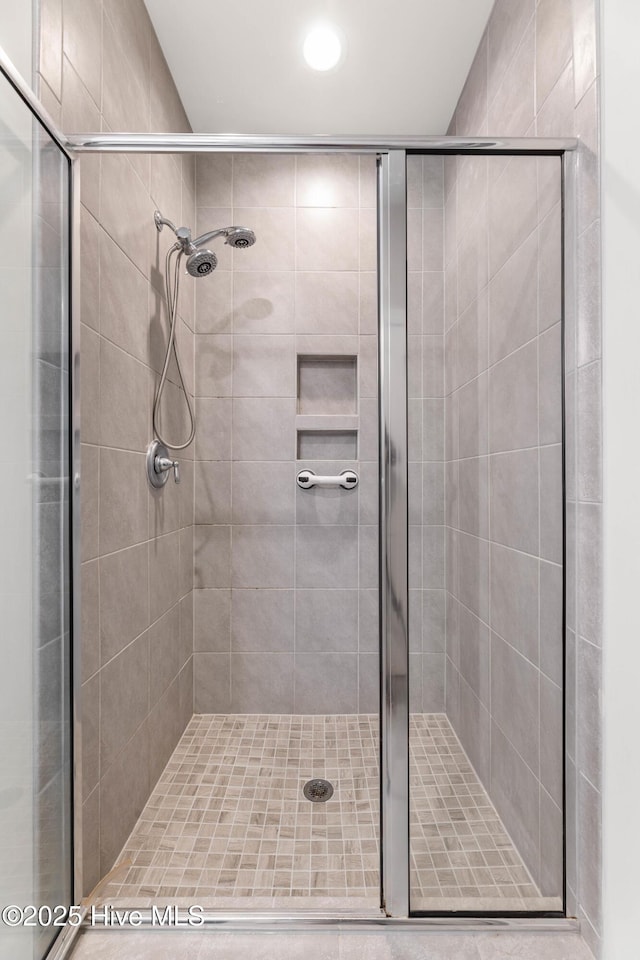 bathroom featuring a shower with shower door