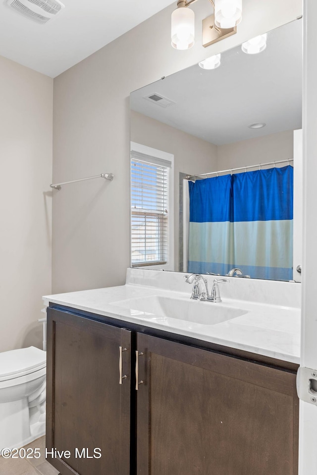 bathroom with vanity, curtained shower, and toilet