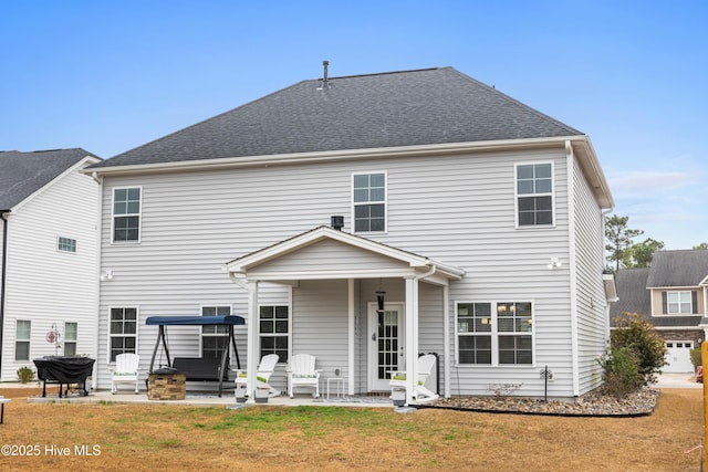 back of house with a yard and a patio