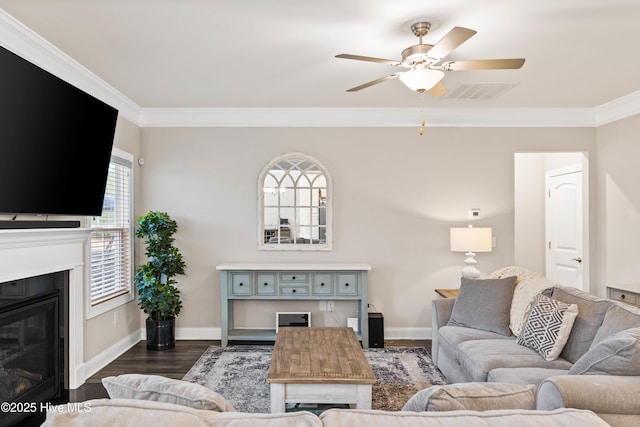 living room featuring dark hardwood / wood-style flooring, crown molding, and ceiling fan