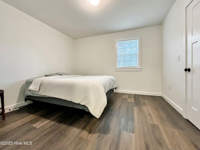 bedroom with dark hardwood / wood-style floors