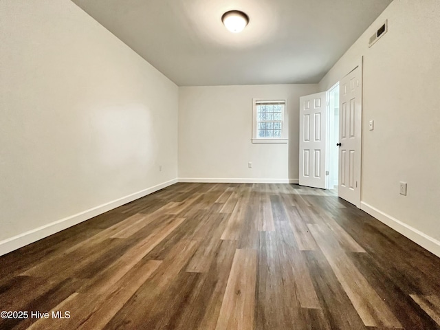 empty room featuring dark hardwood / wood-style flooring