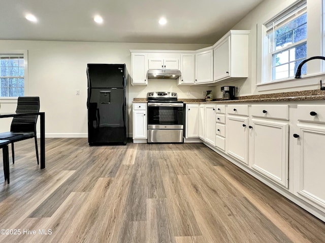 kitchen featuring white cabinets, black fridge, stainless steel range with electric cooktop, and light hardwood / wood-style floors